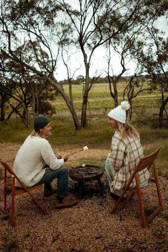 A couple roasting marshmallows outside, enjoying slow moments and nature – one of the relaxing things to do in Barossa Valley.